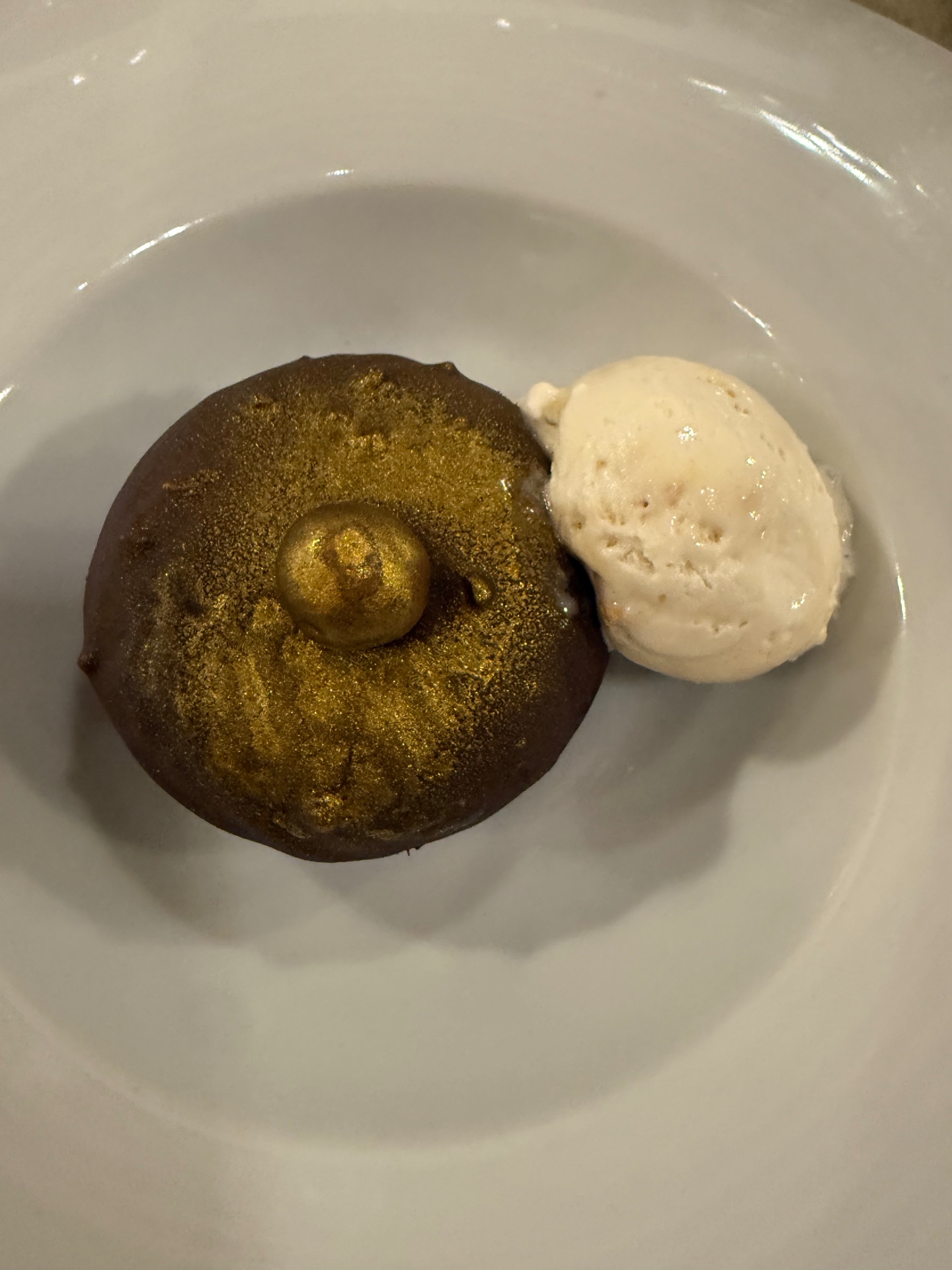 Chocolate dessert with gold dust and ice cream