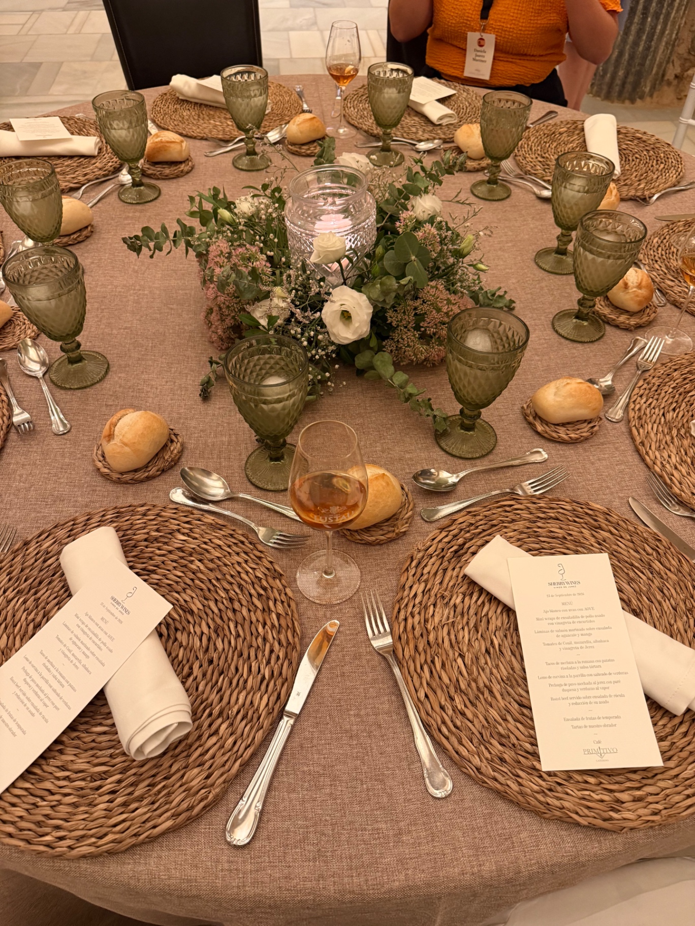 Round table set for a sherry dinner with woven placemats