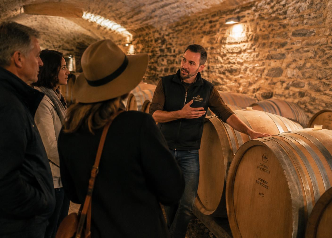 Winemaker guiding visitors through a barrel cellar